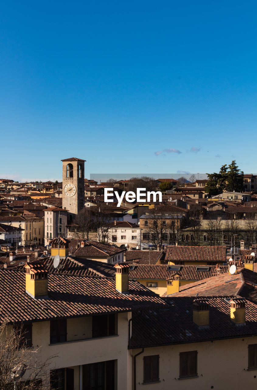 Aerial view of townscape against blue sky