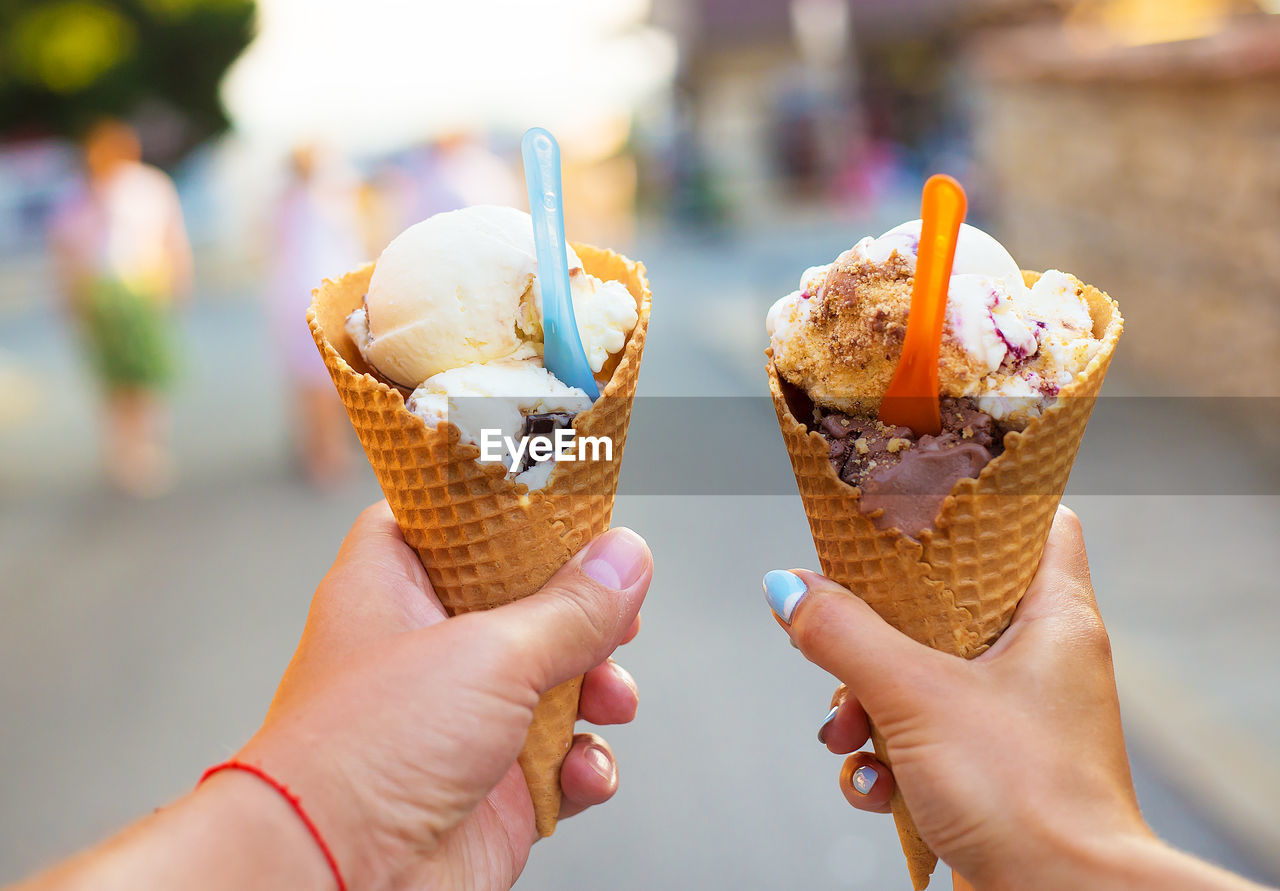 Beautiful bright ice cream with different flavors in the hands of a couple.