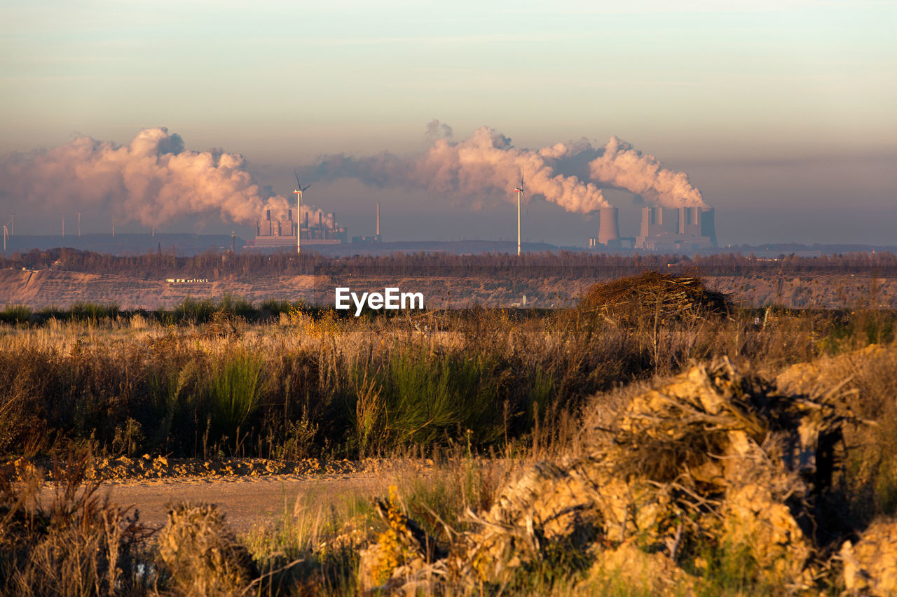 SMOKE EMITTING FROM FACTORY AGAINST SKY DURING SUNRISE