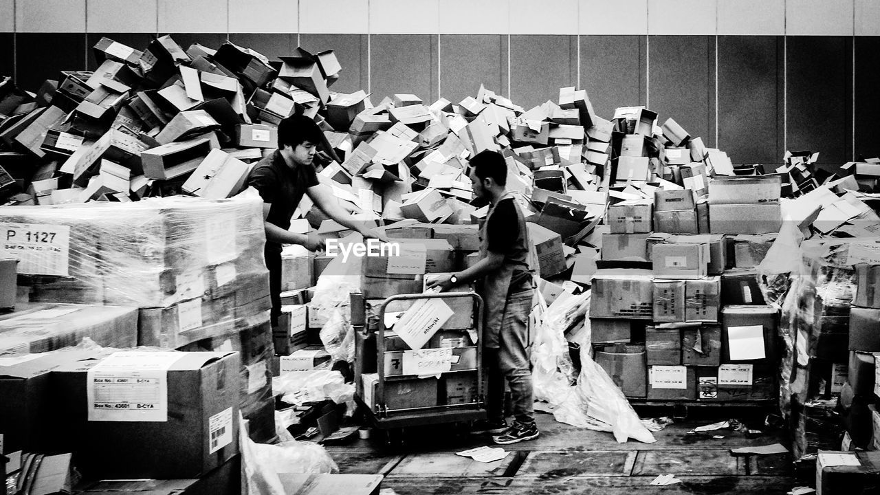 Men working with cardboard boxes at warehouse