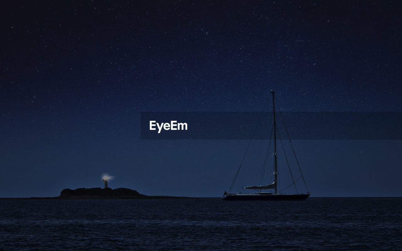 Sailboat sailing on sea against sky at night