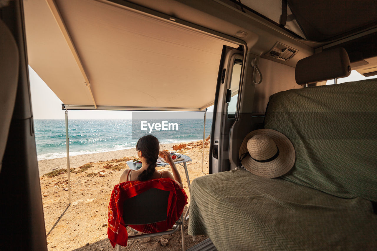 Rear view of woman sitting in train at beach