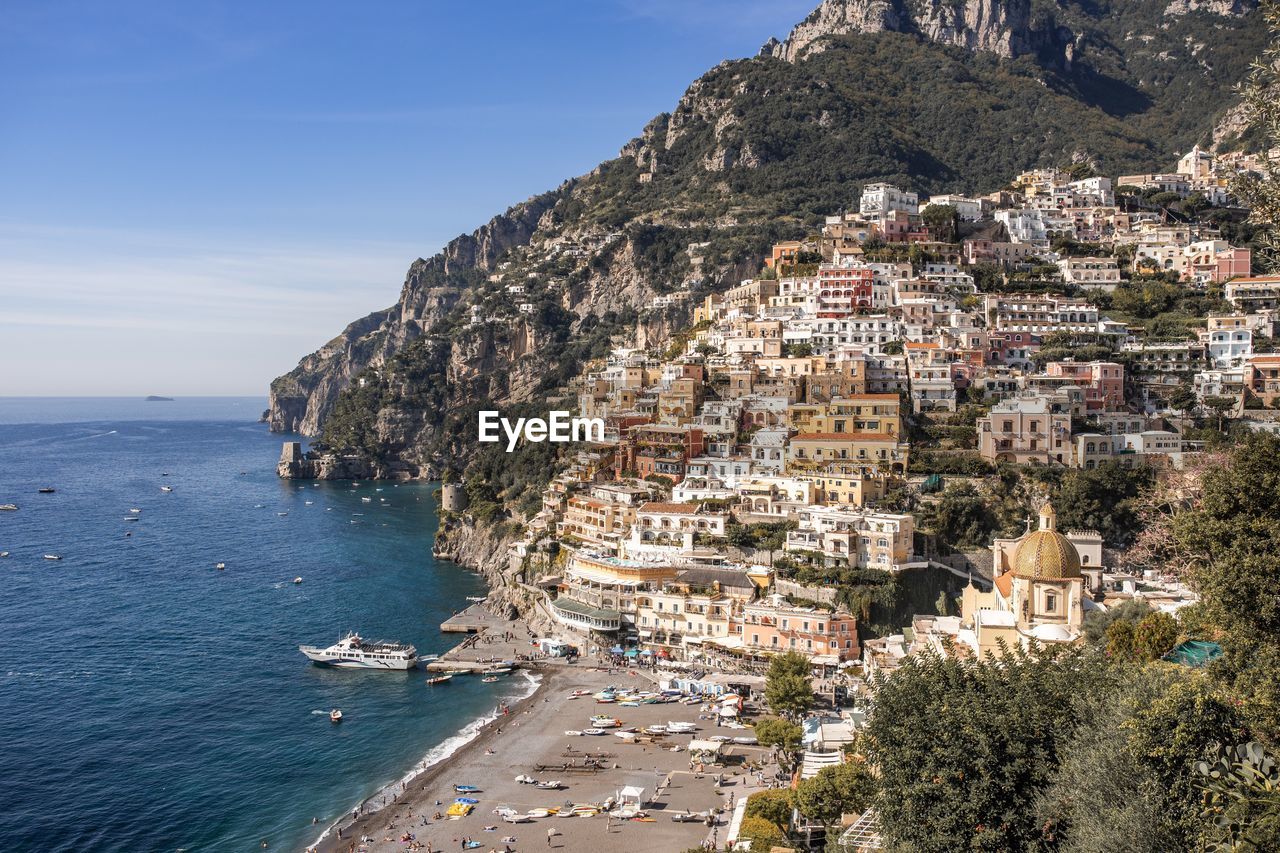 Aerial view of town by sea against sky