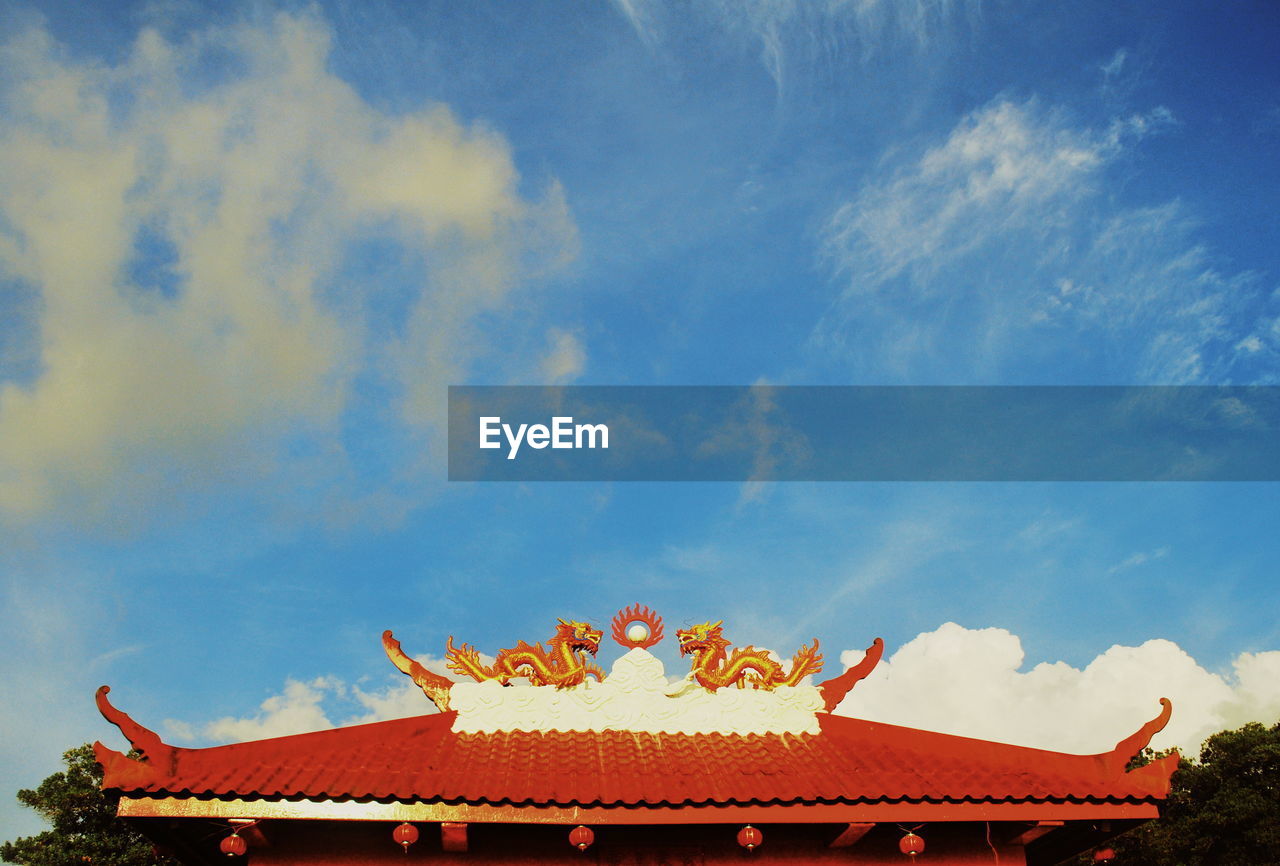 HIGH SECTION OF TRADITIONAL BUILDING AGAINST BLUE SKY