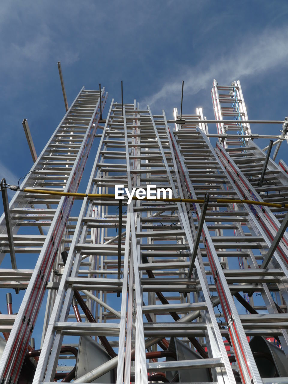 Low angle view of ladders against blue sky