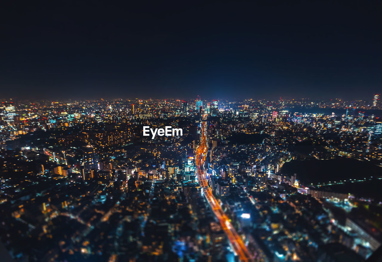 Aerial view of illuminated cityscape against clear sky
