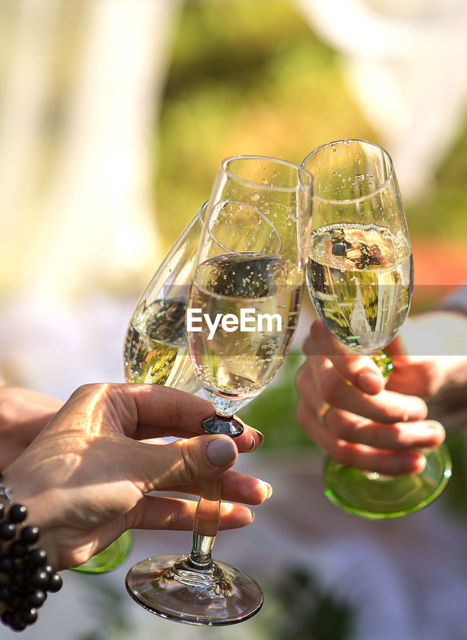 Cropped hands of friends toasting champagne flutes in party