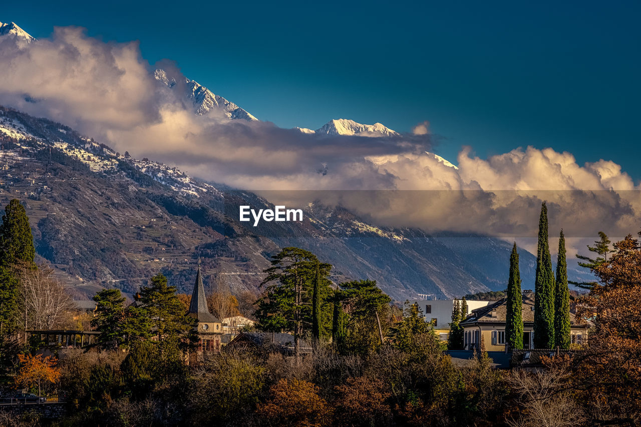 Panoramic view of trees and buildings against sky