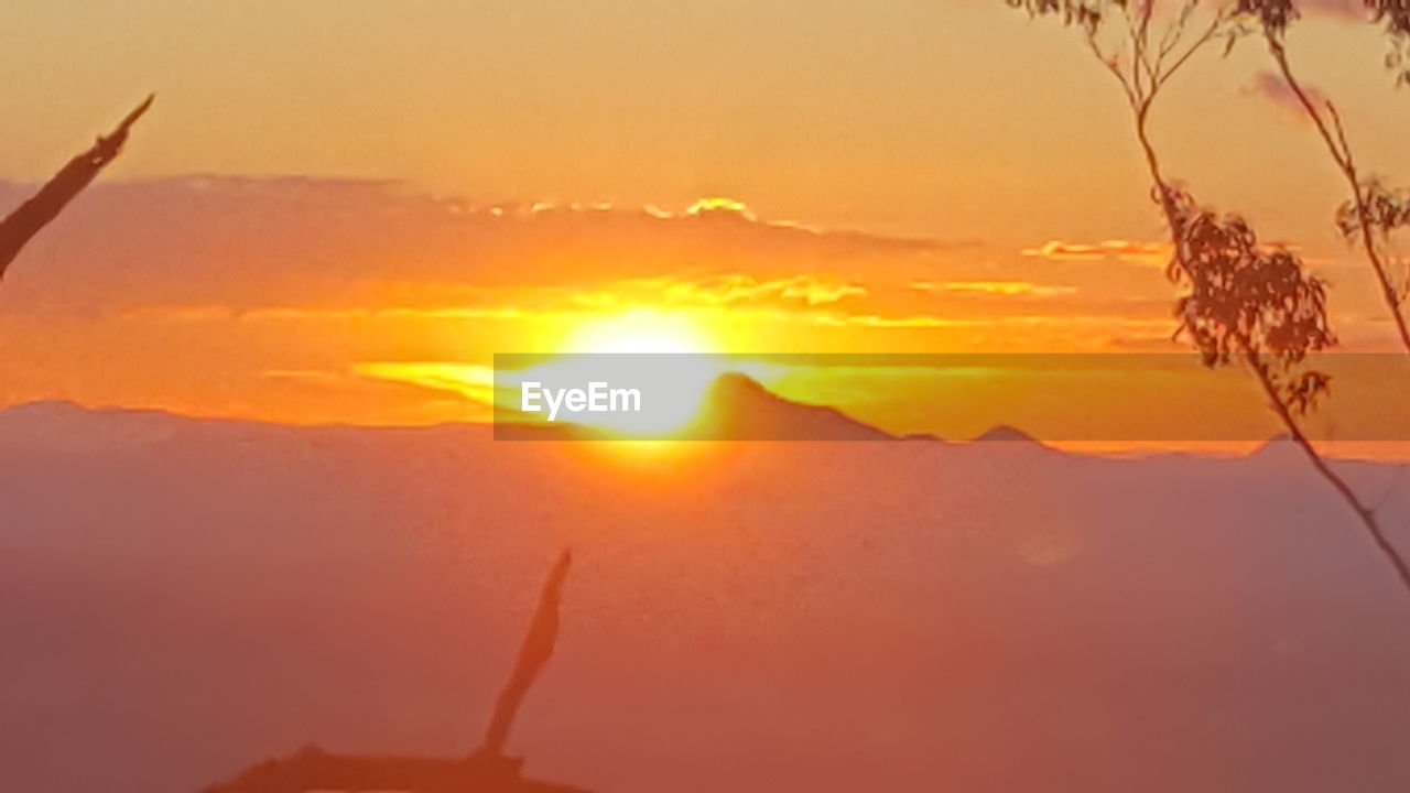 Close-up of orange mountain against sky during sunset