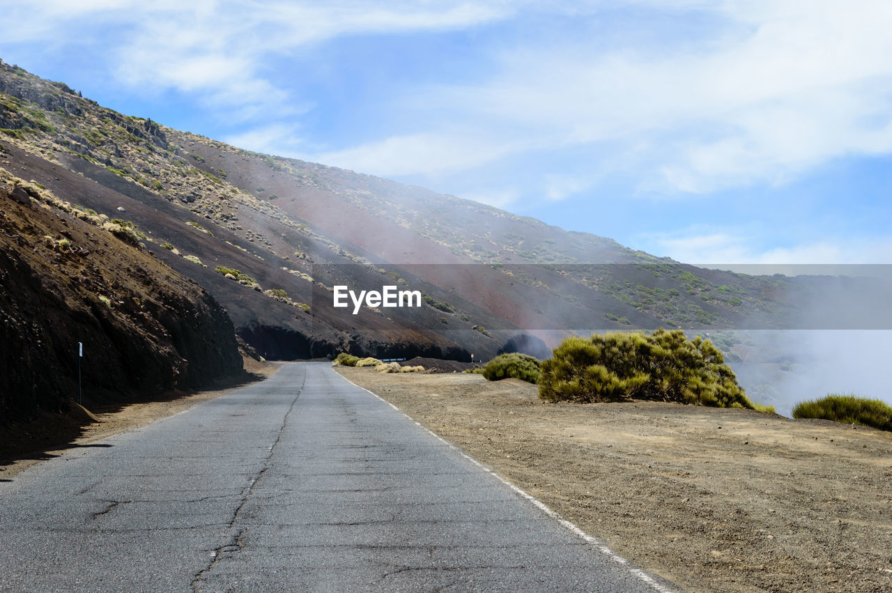 Road amidst mountains against sky