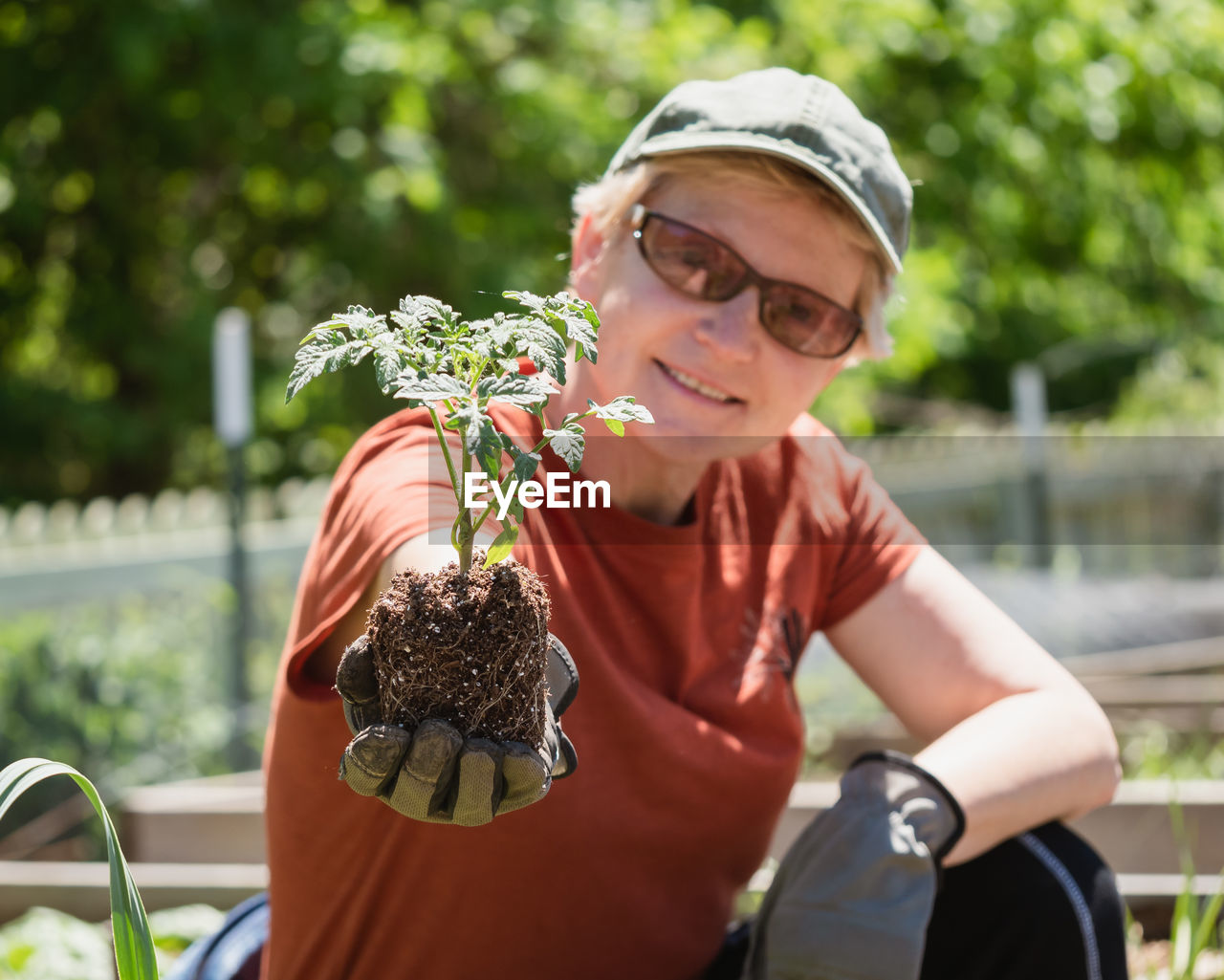 Portrait of smiling woman holding plant