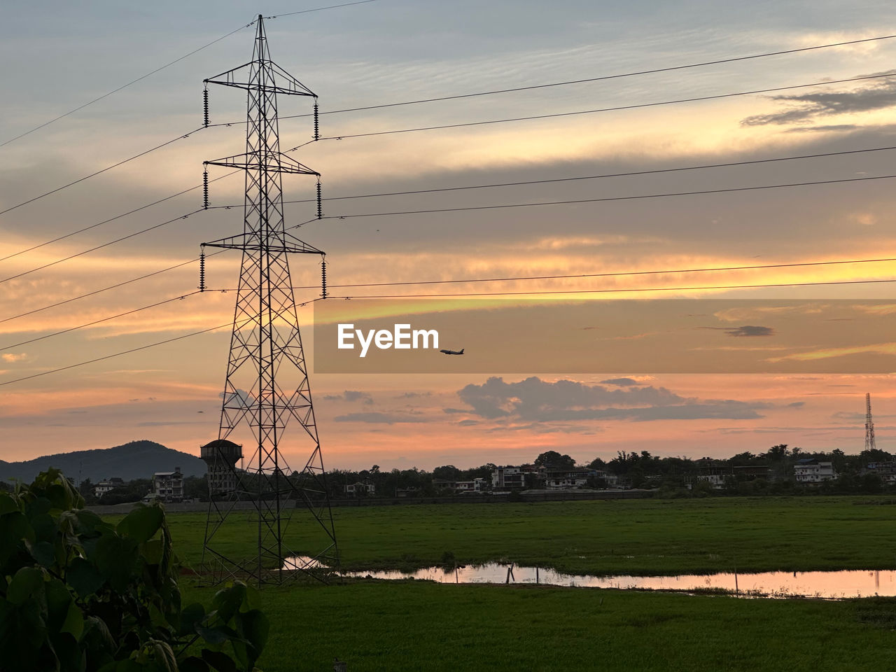 electricity, technology, cable, sky, electricity pylon, power supply, power generation, sunset, environment, power line, landscape, nature, cloud, transmission tower, overhead power line, plant, land, no people, silhouette, architecture, tower, agriculture, built structure, field, scenics - nature, grass, orange color, beauty in nature, rural scene, outdoors, electrical supply, dramatic sky, horizon, outdoor structure, dusk, business finance and industry, environmental conservation, outdoor power equipment, twilight, tranquility, wind, power cable, industry, in a row, power station, romantic sky, high voltage sign, non-urban scene, sun
