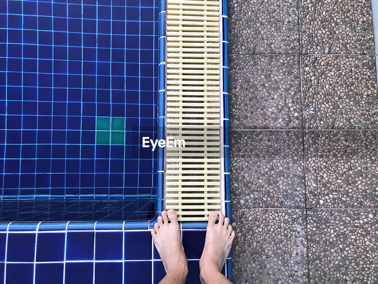 Low section of man standing at poolside