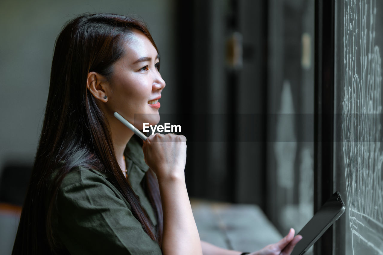 side view of young woman using mobile phone