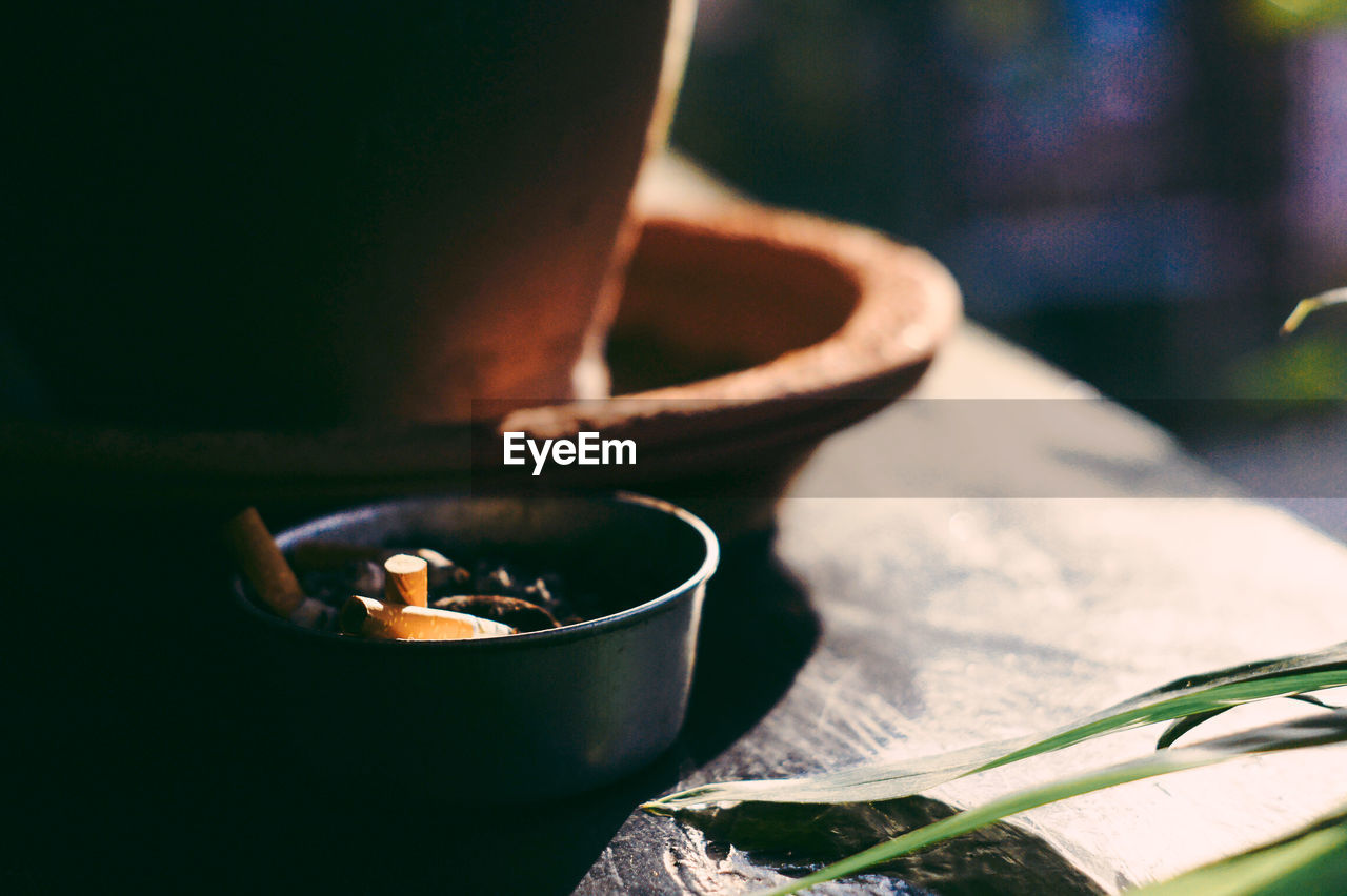 High angle view of cigarette butts in bowl on table