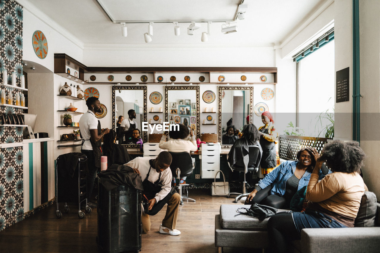 Multiracial barbers and customers in hair salon