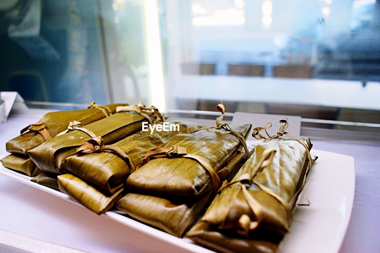 Close-up of food wrapped in banana leaves on tray