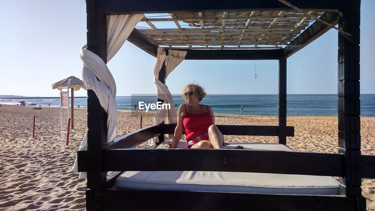 rear view of woman sitting on pier