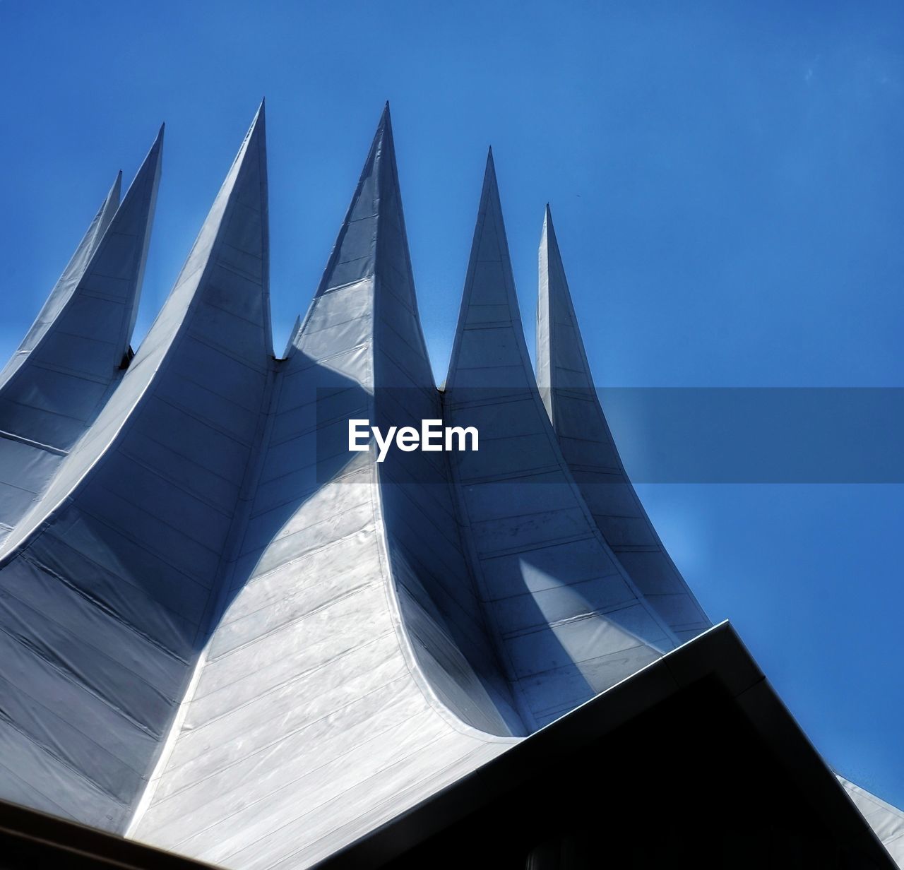 Low angle view of modern building against clear blue sky