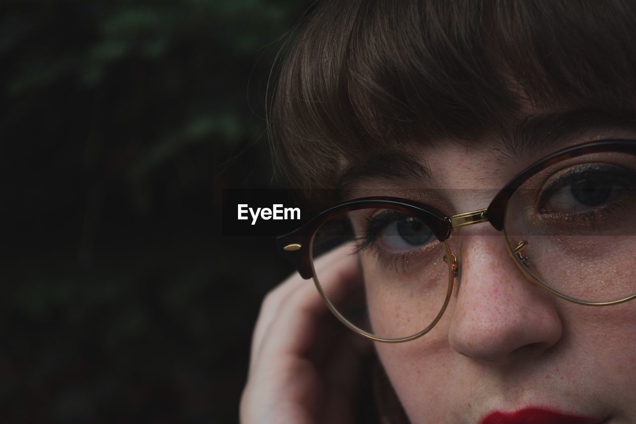 Close-up portrait of woman in eyeglasses outdoors