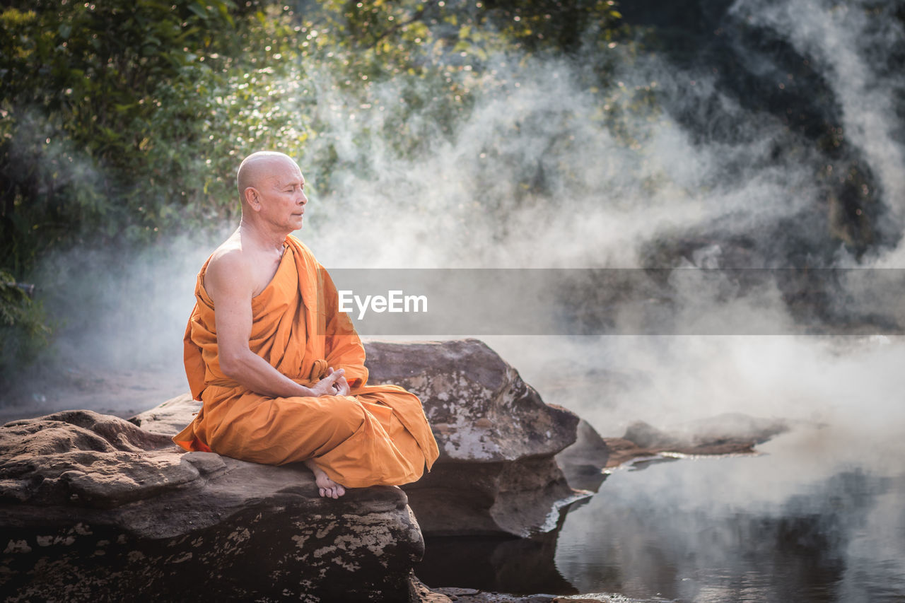 Man meditating on rocks