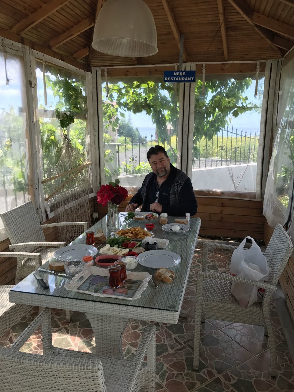 PORTRAIT OF SMILING MAN STANDING BY TABLE IN CAFE