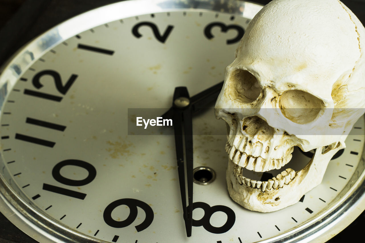 High angle view of human skull on clock