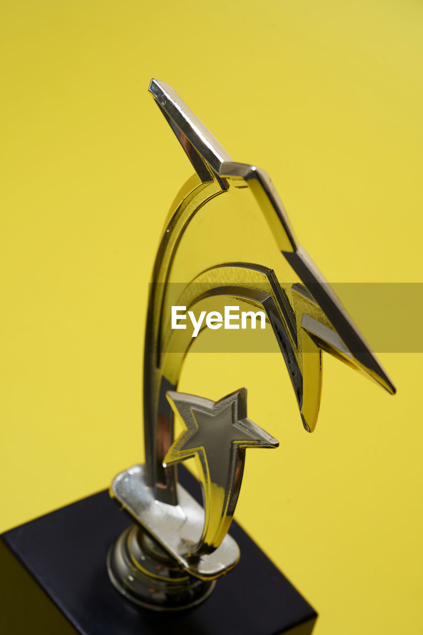 Close up of trophy on yellow background