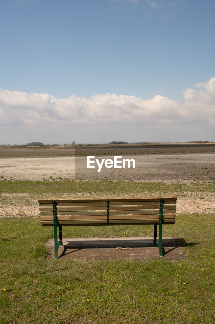 bench, sky, seat, grass, nature, landscape, land, empty, tranquility, environment, furniture, scenics - nature, absence, tranquil scene, park bench, horizon, cloud, beauty in nature, rural area, plant, wood, day, no people, field, natural environment, outdoors, non-urban scene, plain, relaxation, grassland, rural scene, tree, park, prairie, sunlight, training bench, green, chair, water, idyllic