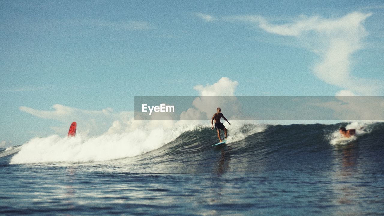 Man surfing on sea against sky