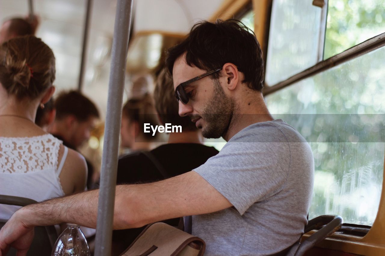 Man wearing sunglasses while sitting in bus