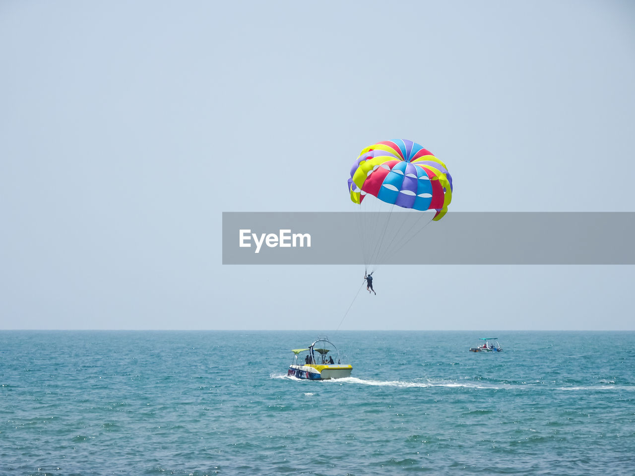 People in sea against clear sky