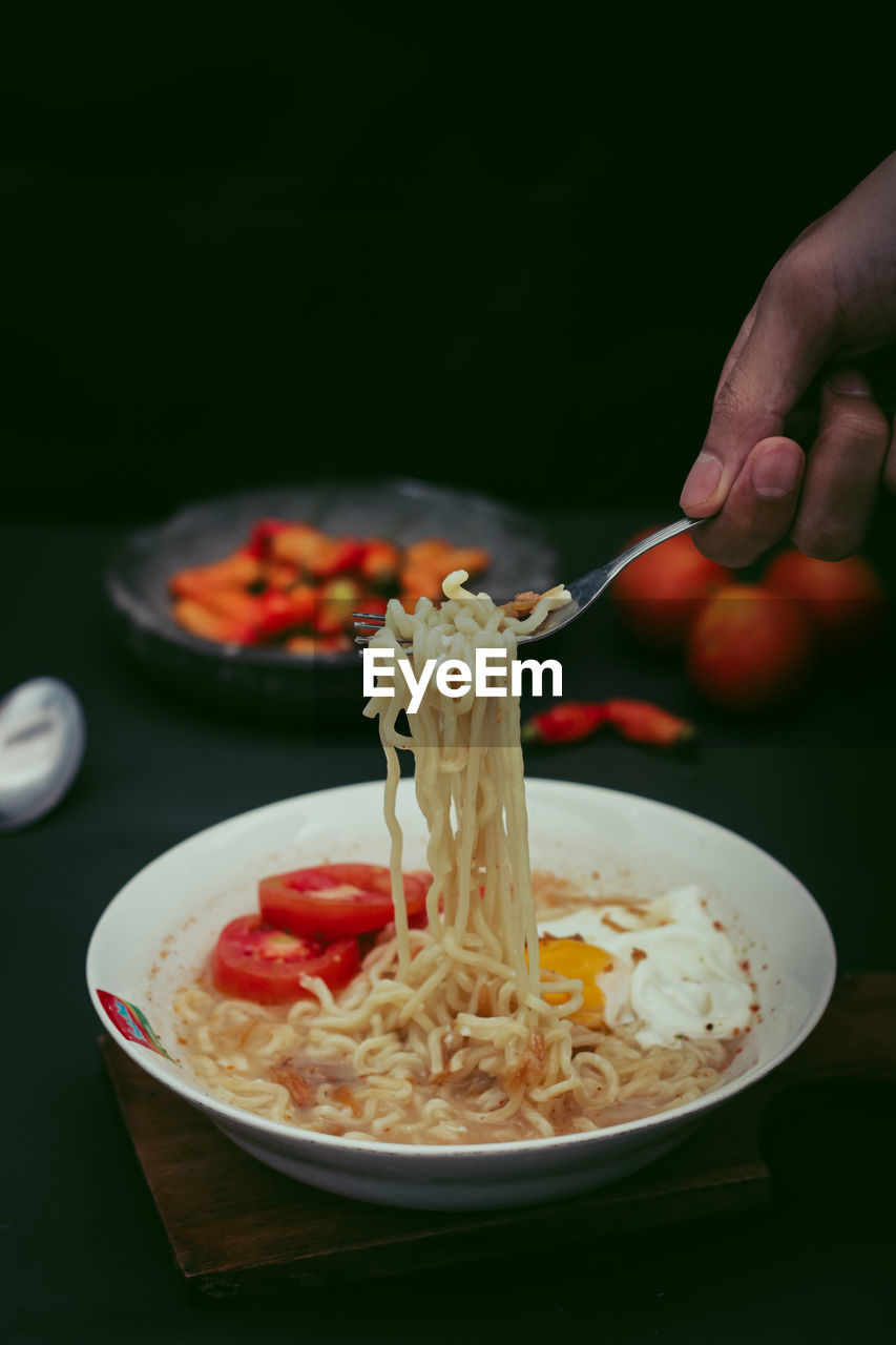 Cropped hand of person having food or noodle