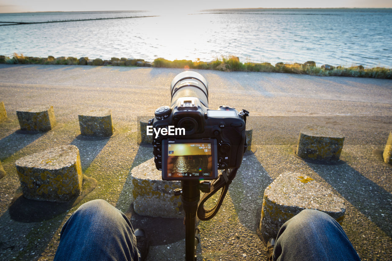 CLOSE-UP OF CAMERA AGAINST SEA