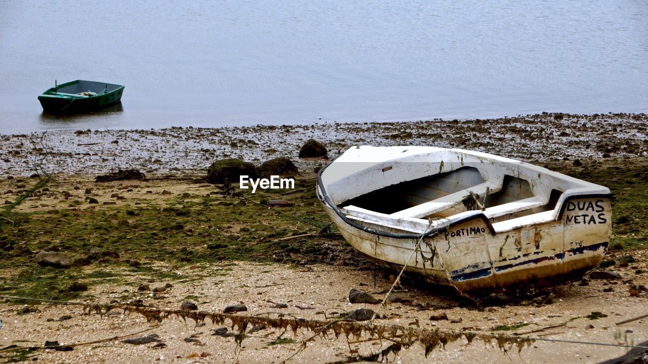 ABANDONED BOAT MOORED ON BEACH