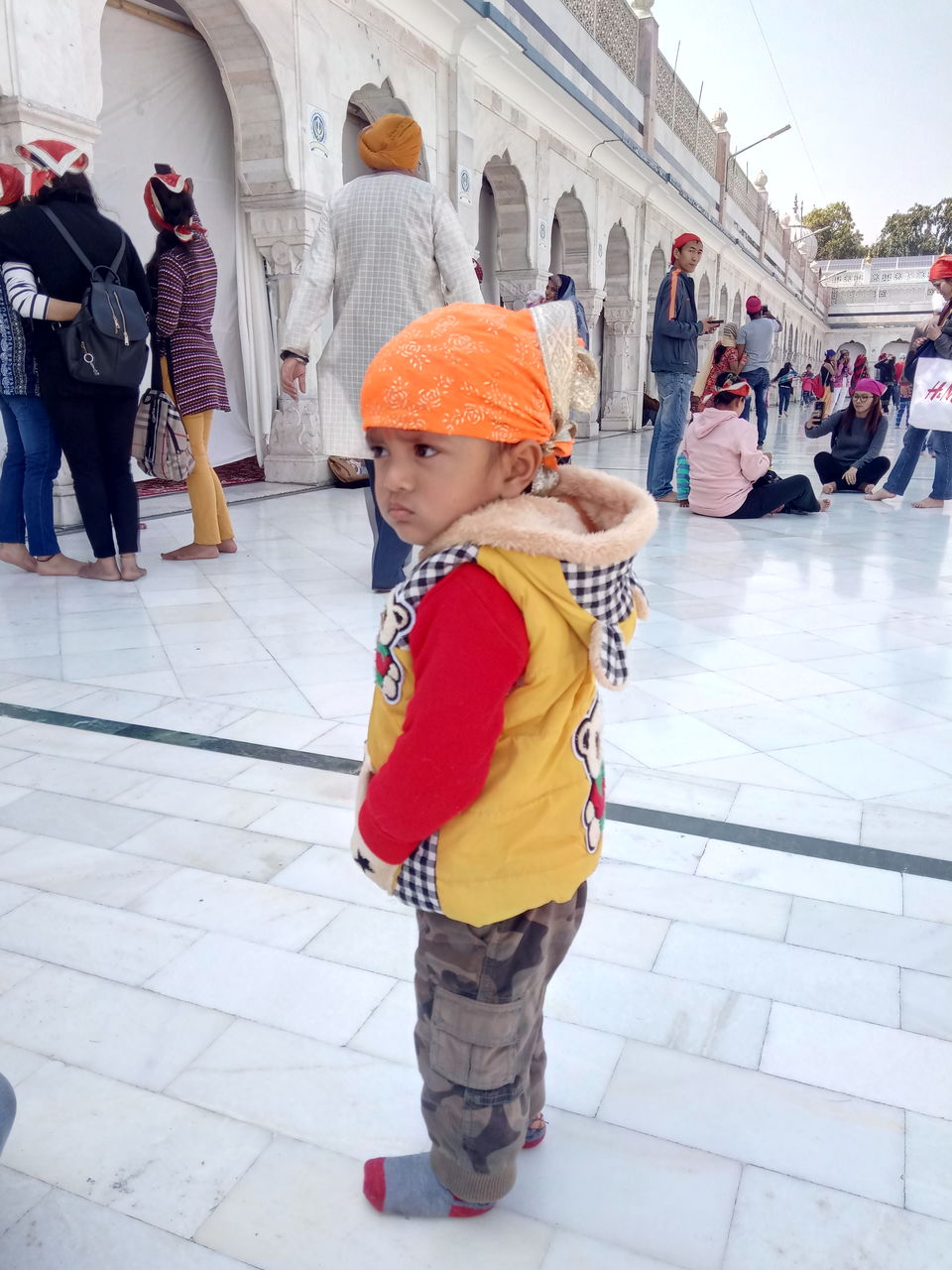 Boy looking away while standing in temple by people