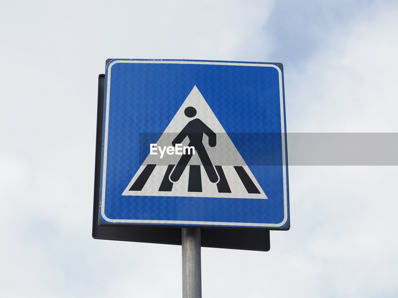 low angle view of road sign against cloudy sky