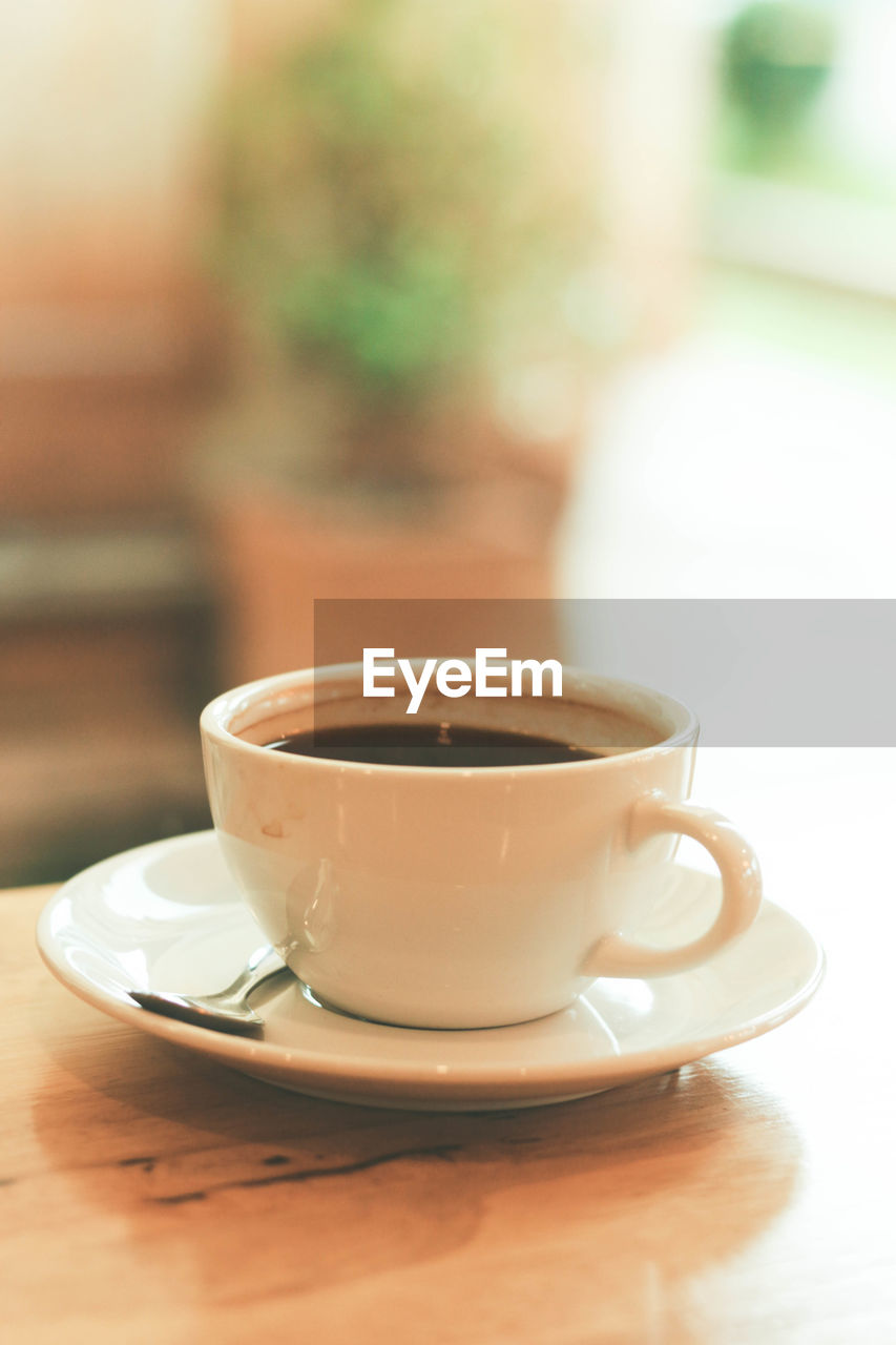 Cup of black coffee on wood table in the afternoon at cafe