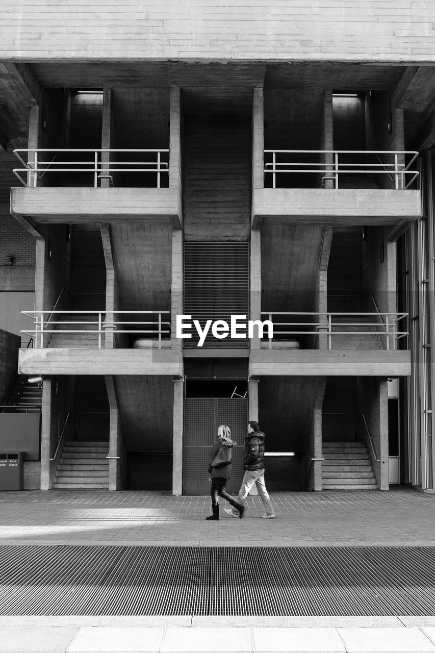 LOW SECTION OF WOMAN STANDING AGAINST BUILT STRUCTURE