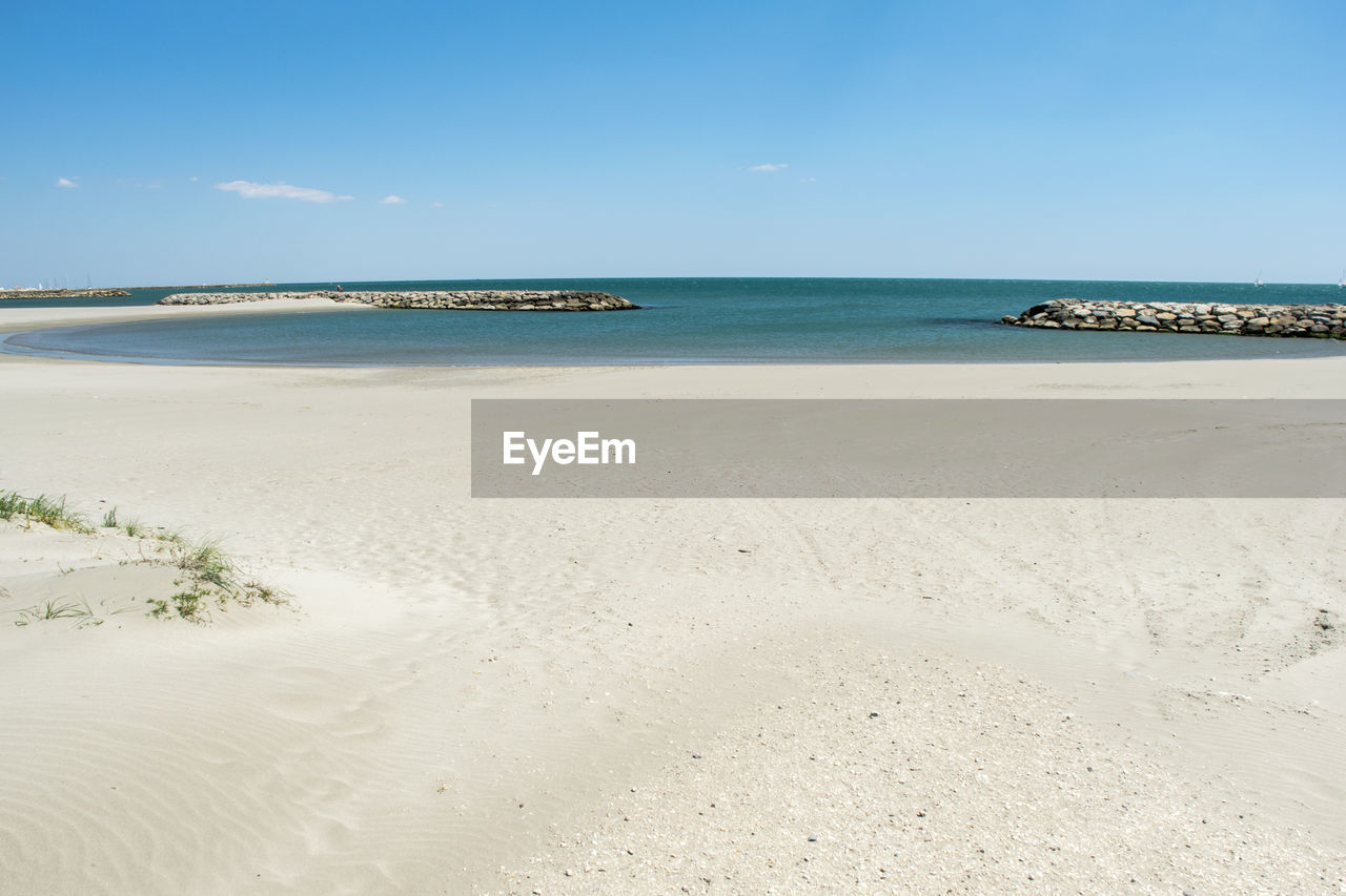 Scenic view of beach against blue sky