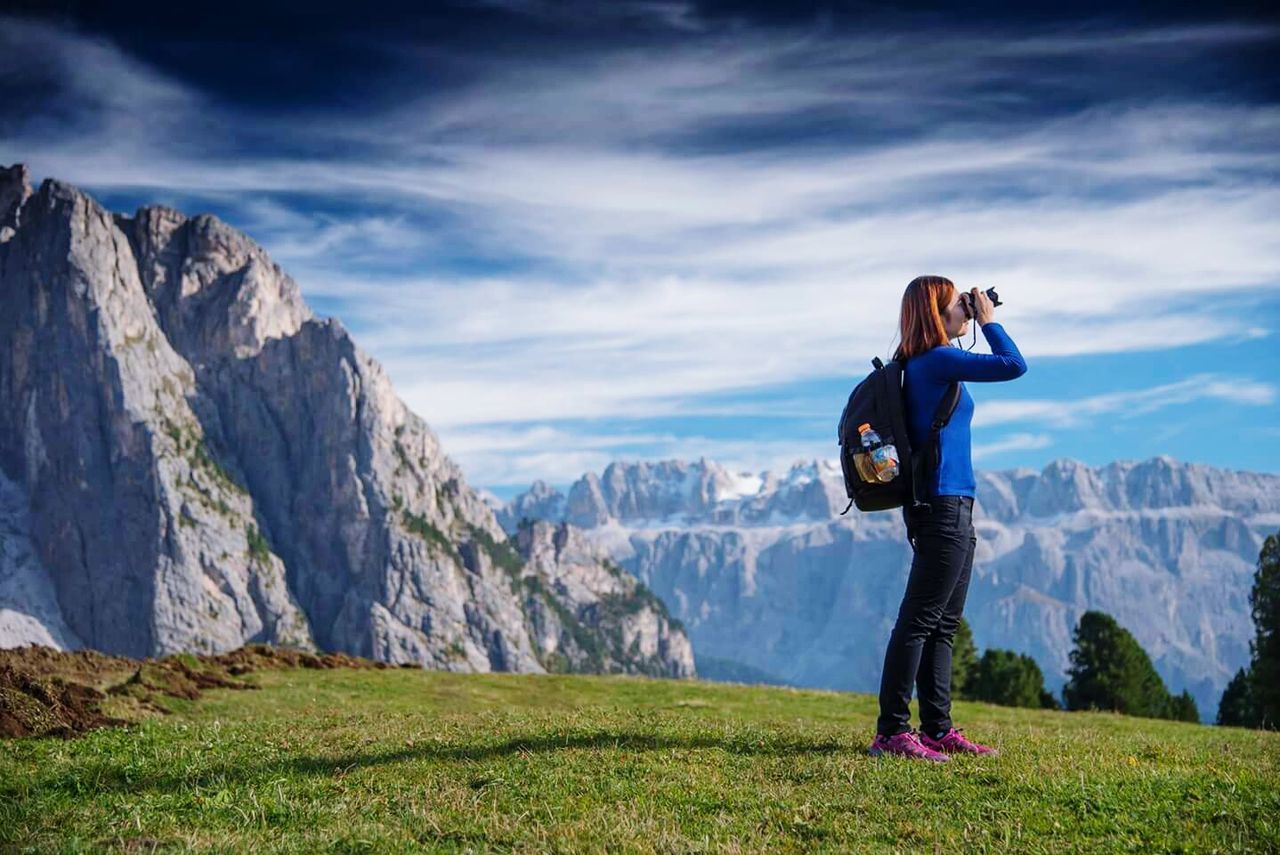 Woman standing on landscape against mountains