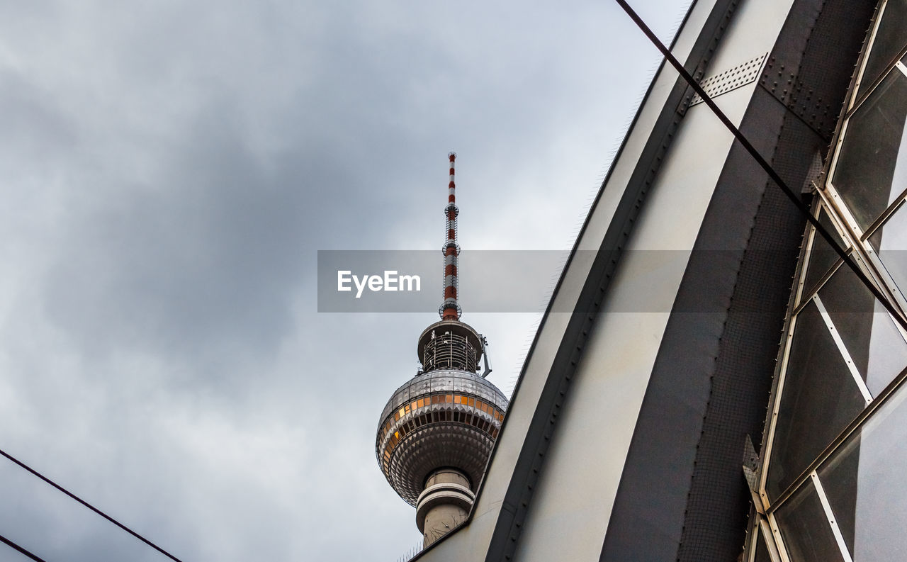 Low angle view of fernsehturm against sky at dusk in city