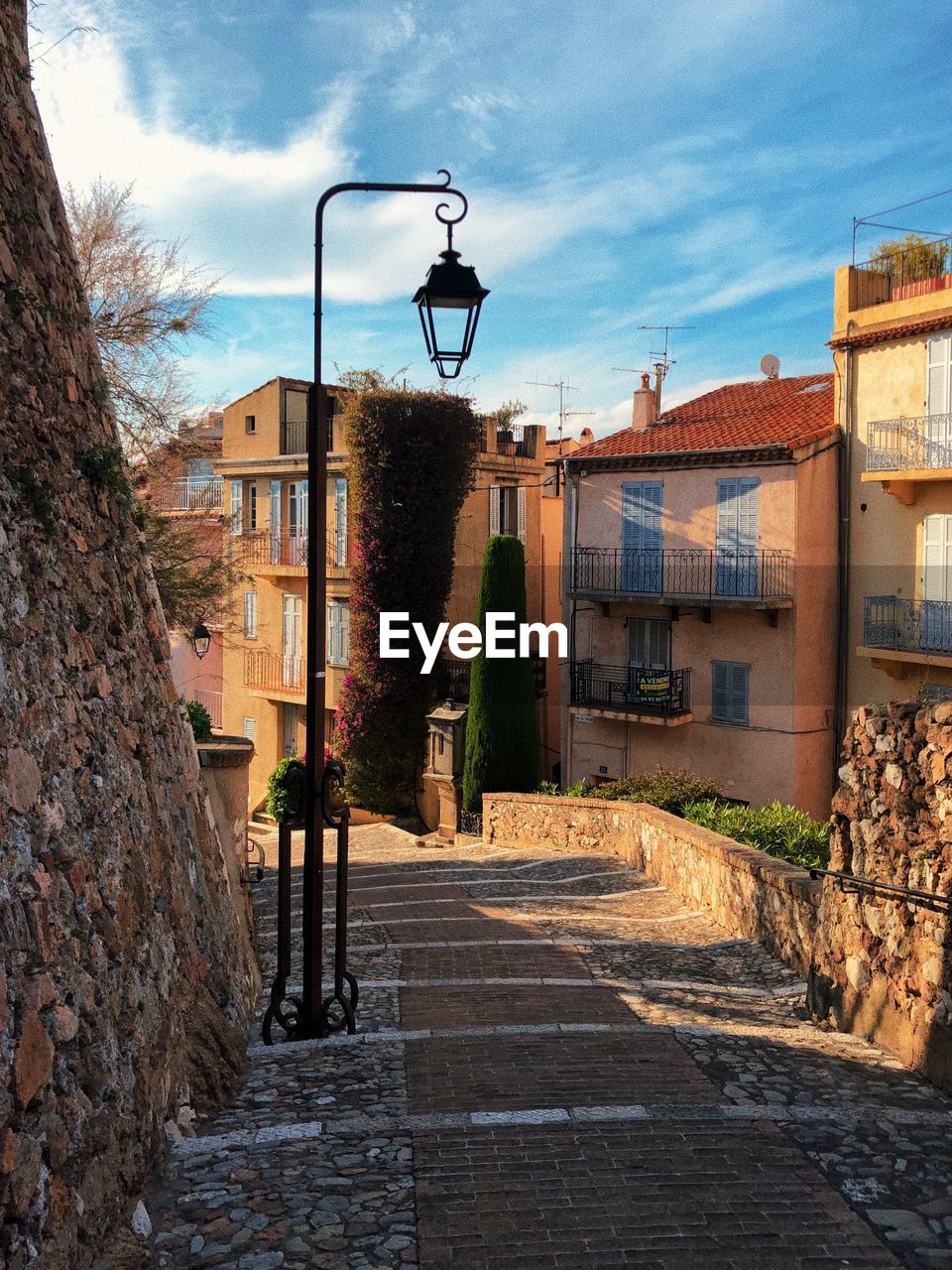 STREET AMIDST HOUSES AGAINST SKY