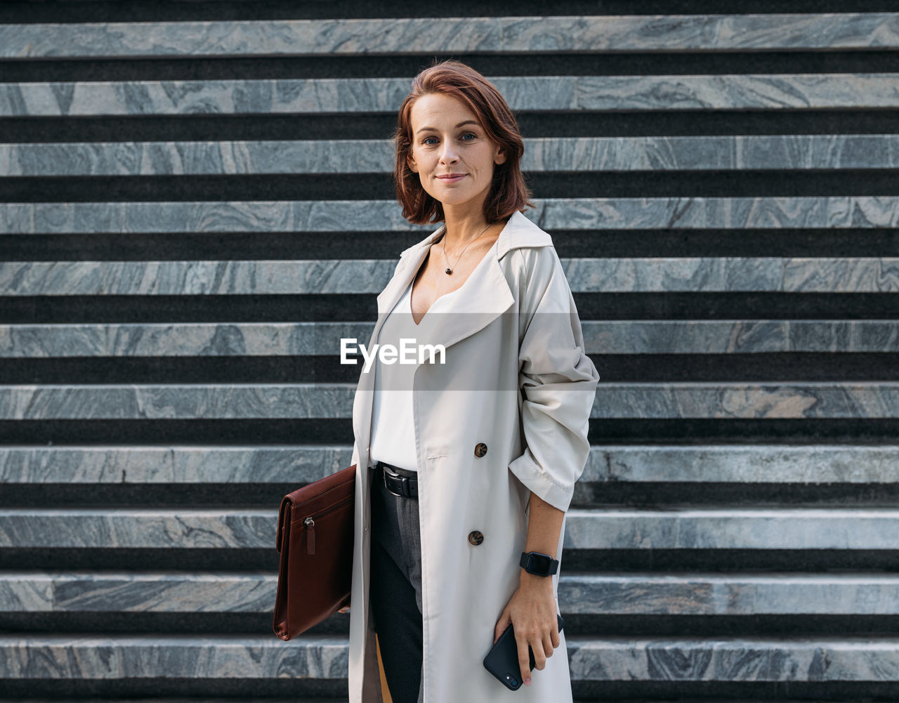 young woman standing against wall