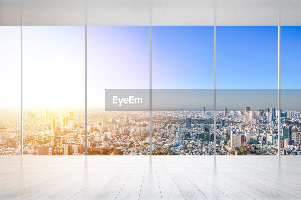 Cityscape seen through glass window during sunset