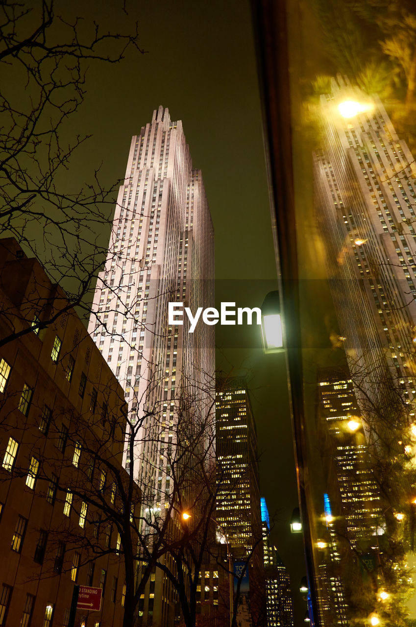 LOW ANGLE VIEW OF ILLUMINATED SKYSCRAPERS AGAINST SKY AT NIGHT