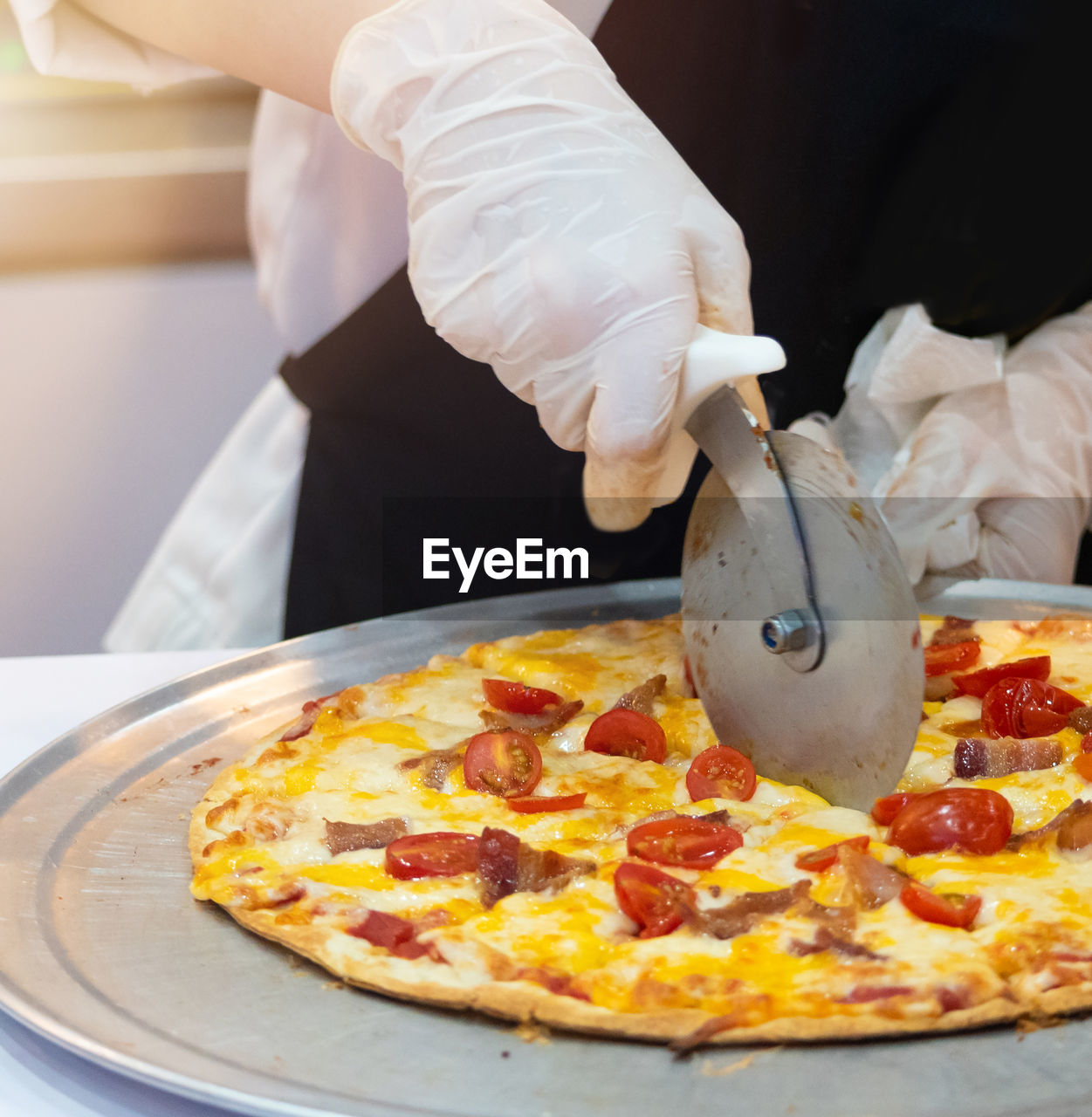 cropped hand of man holding pizza on table