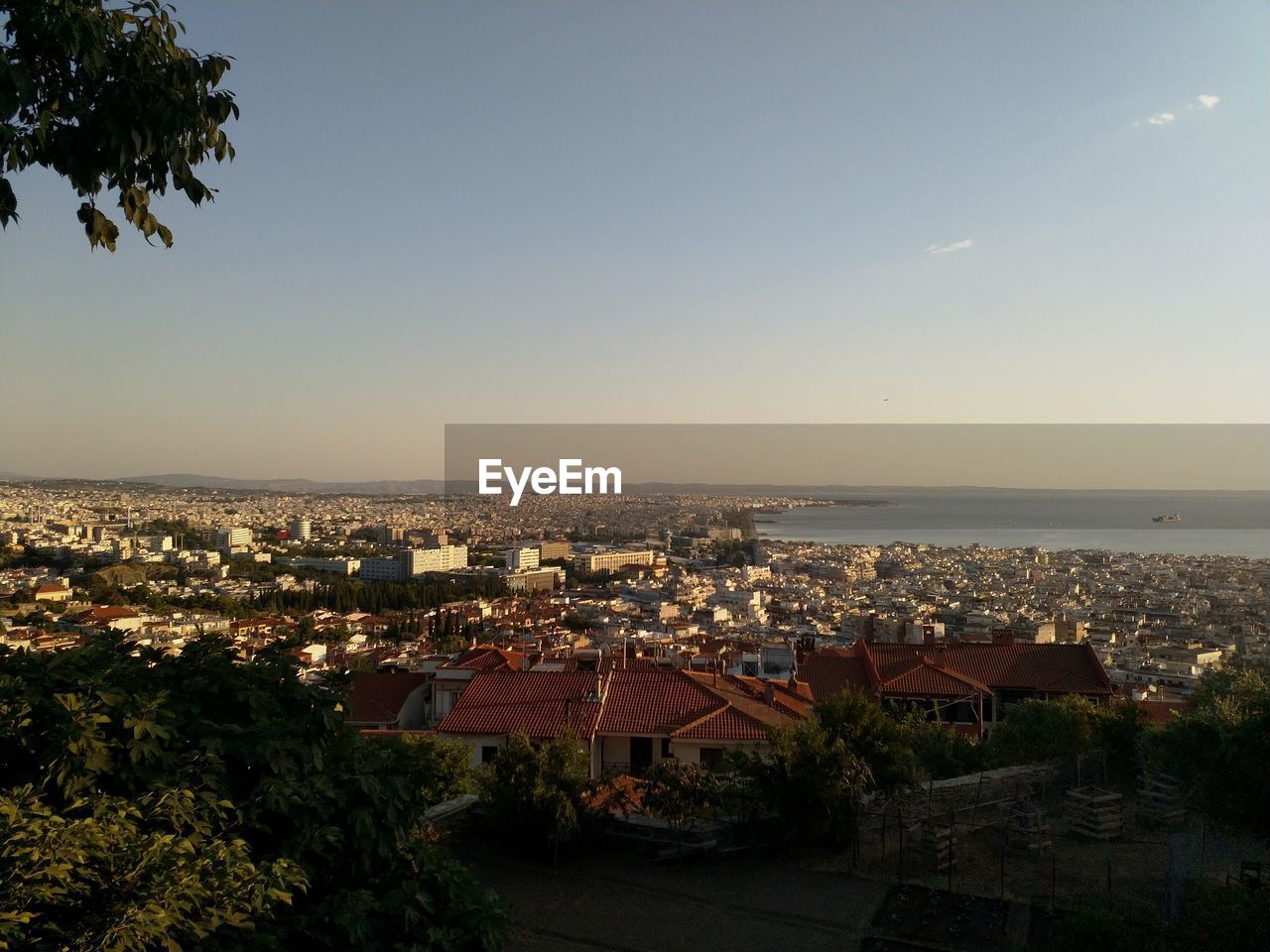 HIGH ANGLE VIEW OF TOWNSCAPE AND SEA AGAINST SKY