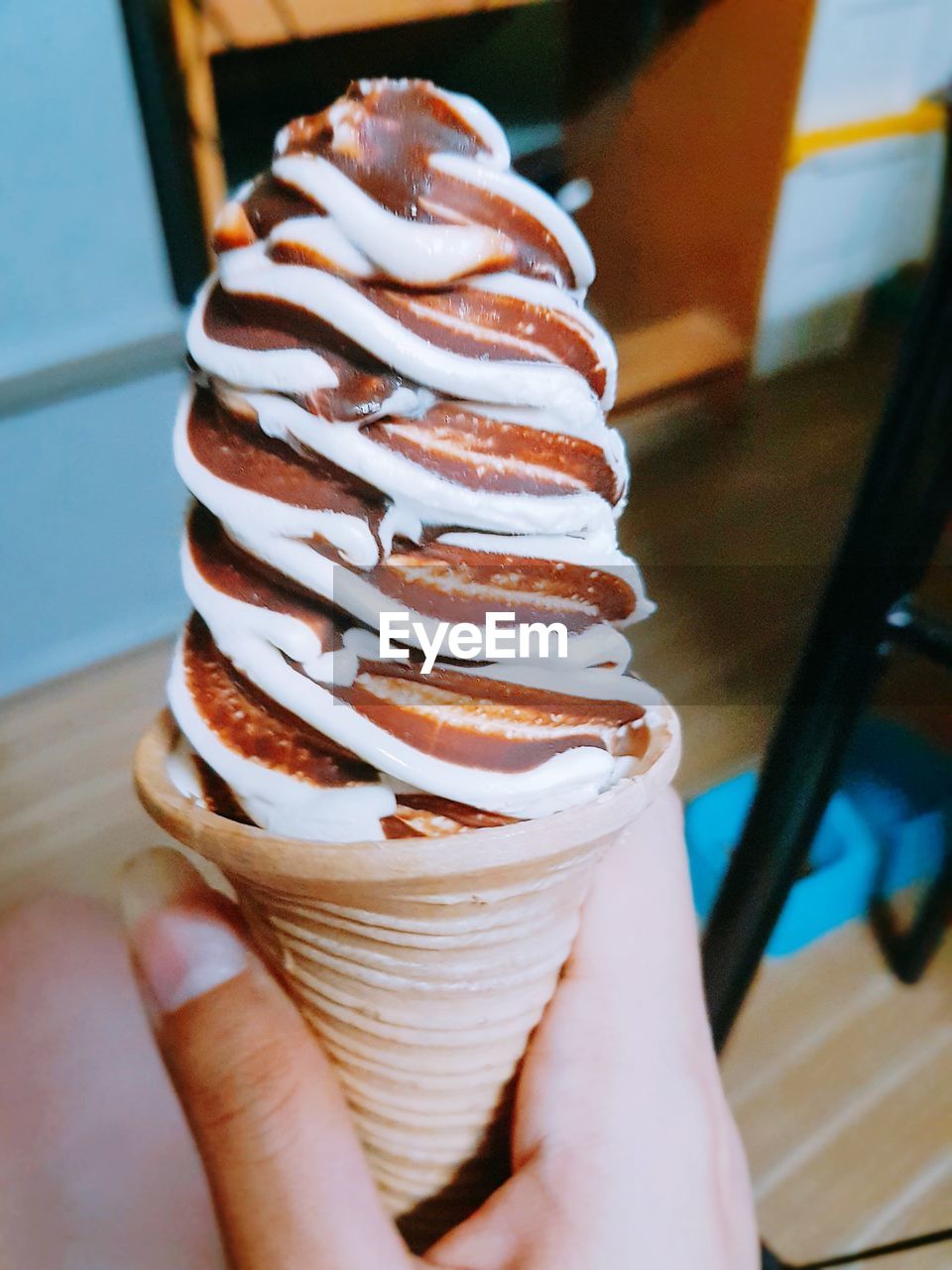 CLOSE-UP OF HAND HOLDING ICE CREAM IN GLASS