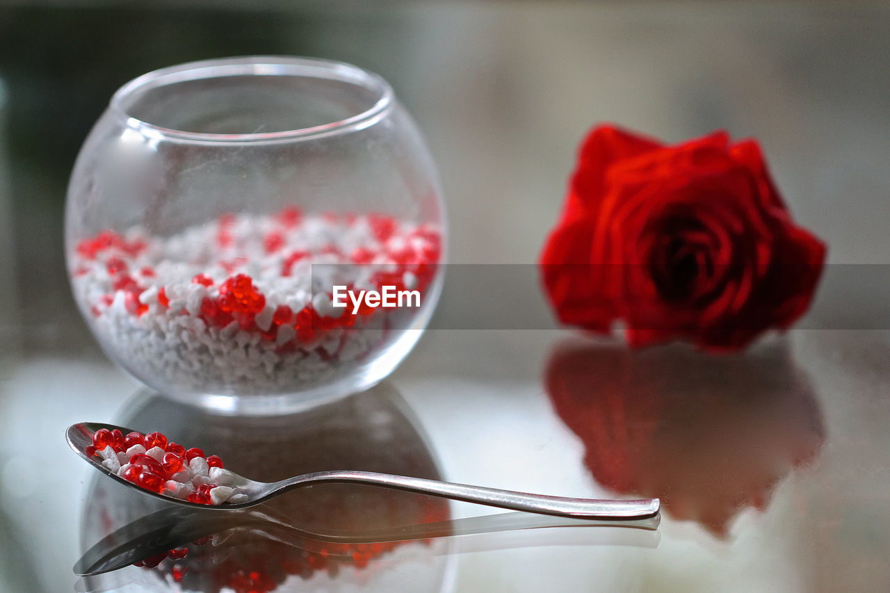 CLOSE-UP OF RED ROSES IN GLASS